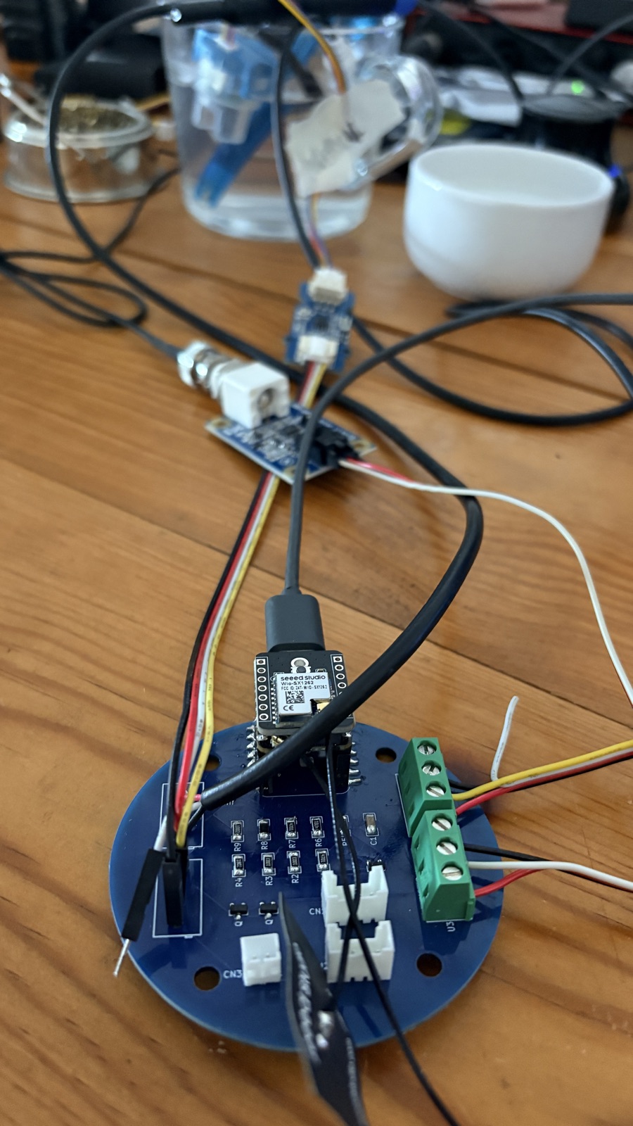 The well-bouy01 board wired to the XIAO and sensors on the bench during staged sensor bring-up